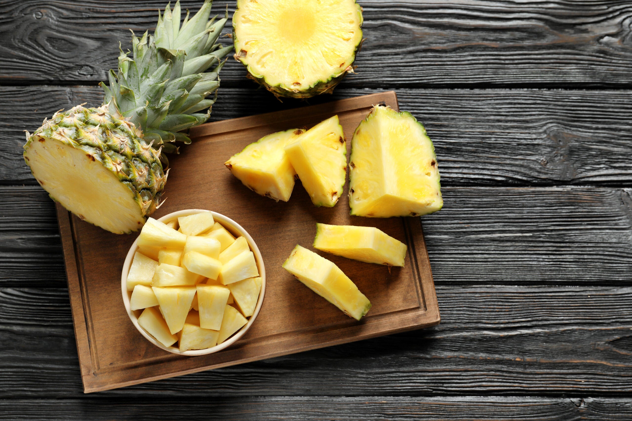 Wooden,Board,With,Fresh,Sliced,Pineapple,On,Table,,Top,View